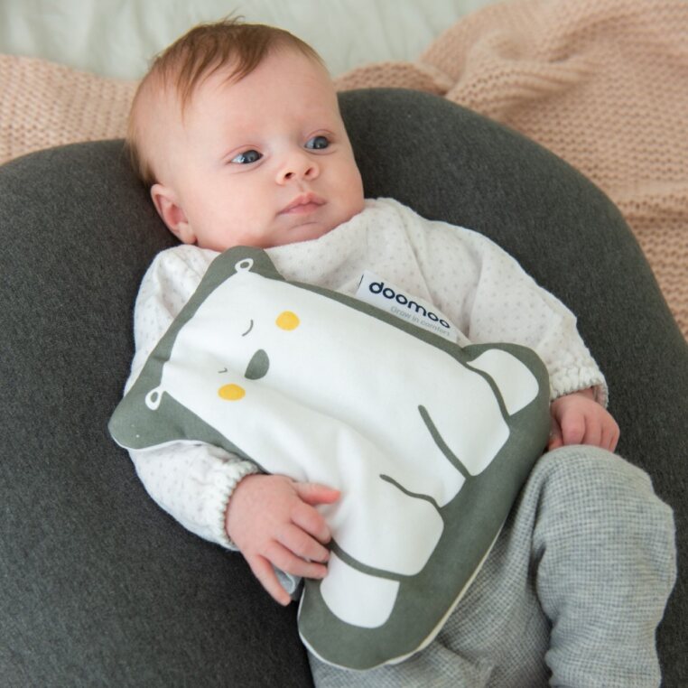 Baby hugging a Doomoo Snoogy stuffed animal