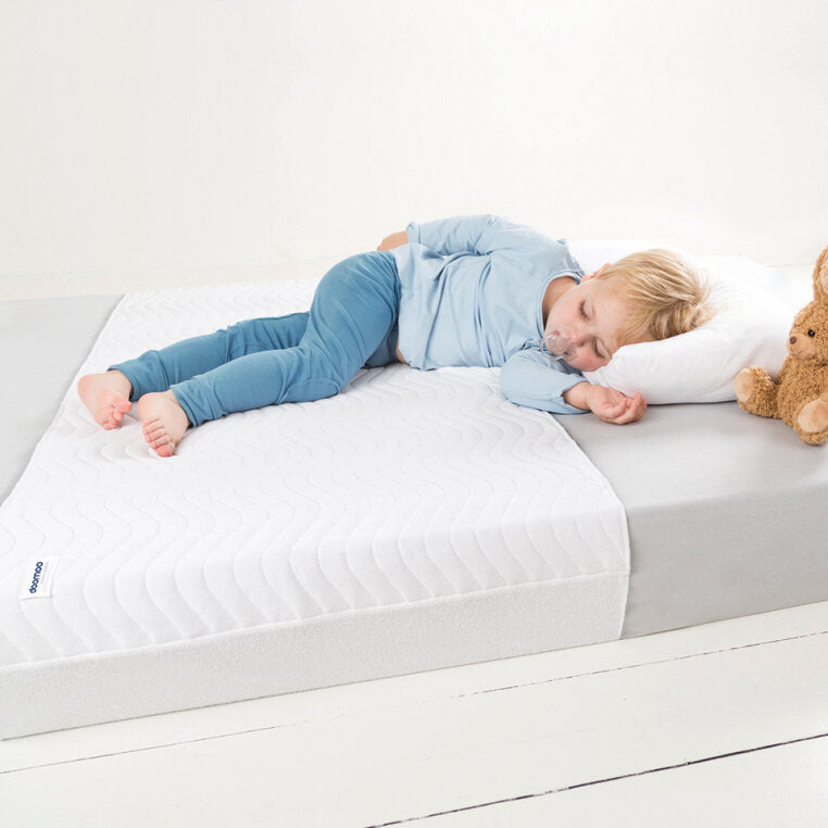 Baby sleeping soundly on a Doomoo Basics Absoplus Bed Pad